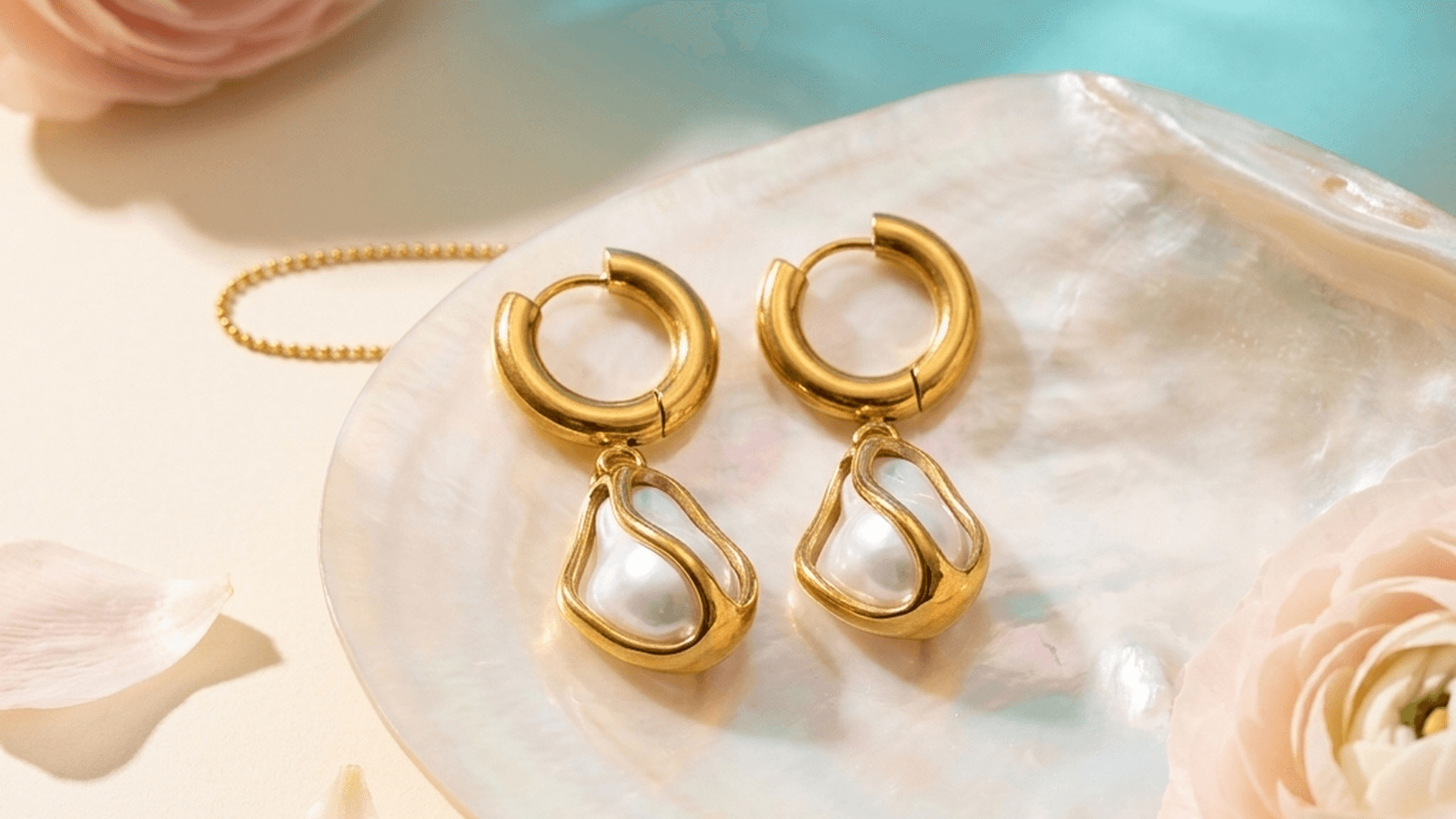Boucles d'oreilles dorées à perle sur un coquillage nacré, entre pétales roses — l'esprit Bloom.
